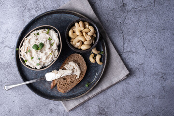 Vegan cashew cheese and a slice of bread on a gray plate.