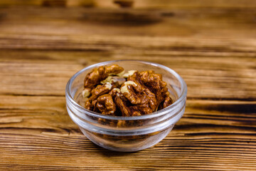 Cores of walnut in glass bowl on a wooden table