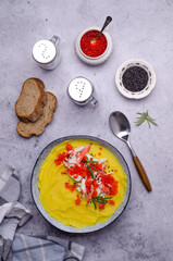 Fototapeta na wymiar Yellow puree with crab meat and red caviar.