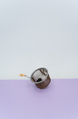 worn metal tea strainer on a lilac paper background
