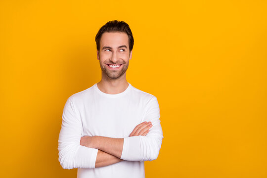 Photo of cheerful glad person folded arms look interested empty space isolated on yellow color background