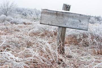 old wooden board pointer on the post. winter outdoor scenery template. blank wooden signage