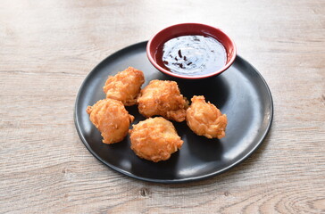 crispy fried squid ball dipping spicy and sweet sauce on plate