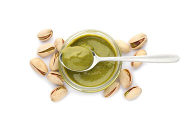 Jar and spoon with delicious pistachio butter on white background, top view