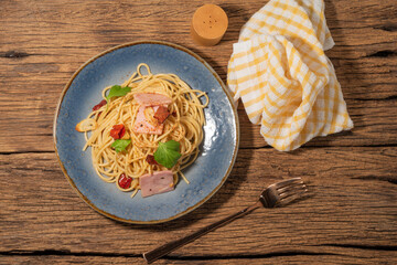 Pasta in black plate on wood background Italian food.