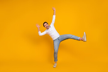 Fototapeta na wymiar Full size photo of funky brunet millenial guy dance wear shirt jeans footwear isolated on yellow background