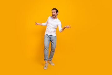 Full size photo of impressed brunet millennial guy go wear shirt jeans shoes isolated on yellow background