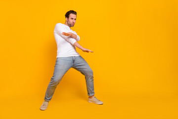 Fototapeta na wymiar Full body photo of nice brunet young guy dance wear shirt jeans shoes isolated on yellow background