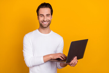 Photo of ceo brunet young guy write laptop wear white outfit isolated on vibrant yellow color background