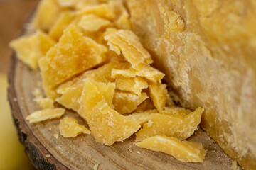 Piece of Parmesan cheese and cheese on the wooden board