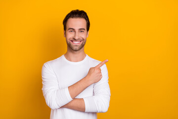 Photo of positive cheerful guy direct finger empty space proposition isolated on yellow color background