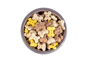 Top view of brown biscuit bones and crunchy organic kibble pieces for dog feed in a metal bowl isolated on white background. Healthy dry pet food concept.