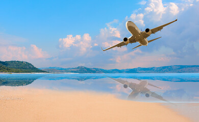 Fototapeta na wymiar Airplane flying above tropical sea with sandy beach at sunset