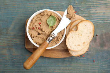 Delicious meat pate with spices, fresh bread and knife on blue wooden table, flat lay