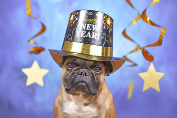 French Bulldog dog wearing New Year's Eve party top hat with text 'Happy new year' in front of blue...
