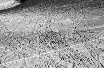 Black and white snowy ski slope with trace from skis and snowboards