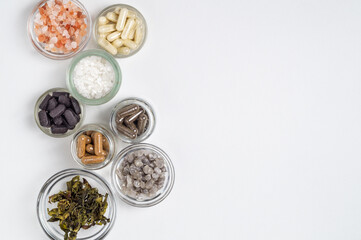 Dietary supplements in capsules, white, gray, pink crystals of sea salt and algae
