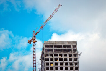 Construction crane and the building against the blue sky