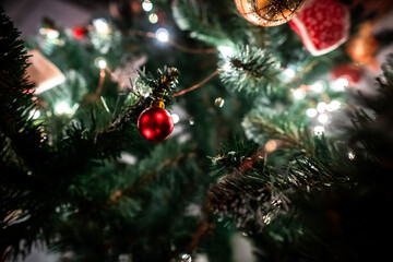 Closeup horizontal footage of Christmas tree decorated with baubles and flashing lights. A New Year pine with bright garland is prepared for celebrating the holiday. Festive atmosphere of coming xmas.