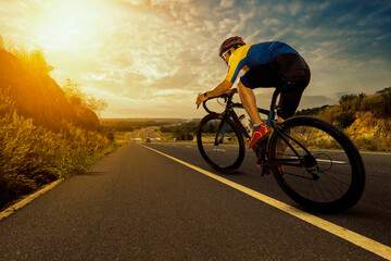 Asian man riding a bicycle on an open road.