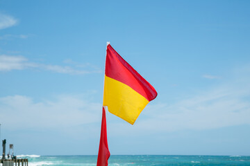 Lifeguard flag flying on the beach at Port Campbell on the Great Ocean Road, Victoria Australia
