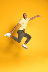 Fototapeta na wymiar Portrait of African young man in casual clothes isolated on yellow color studio background. Concept of human emotions