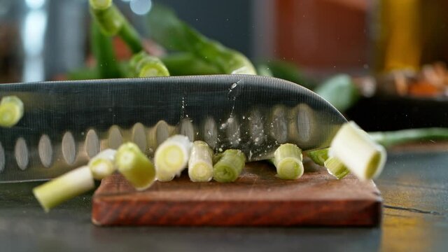 Super slow motion of cutting fresh spring onion with kitchen knife. Filmed on high speed camera, 1000 fps.