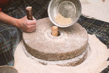 The ancient hand mill or quern stone, grinds the grain into flour. Old handmade grinding stones....