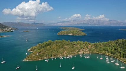 Obraz premium Aerial drone photo of fjord shaped port of Nydri a calm sea safe anchorage for sail boats and yachts famous for trips to Meganisi, Skorpios and other Ionian islands, Lefkada island, Greece