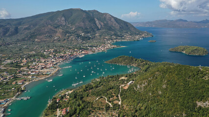 Naklejka na ściany i meble Aerial drone photo of fjord shaped port of Nydri a calm sea safe anchorage for sail boats and yachts famous for trips to Meganisi, Skorpios and other Ionian islands, Lefkada island, Greece