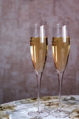 Two glasses of champagne close-up on a gray background.
