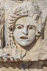 Fototapeta na wymiar Ancient greek stone carvings in the yellow limestone rock. Facade of the building decoration in antique style