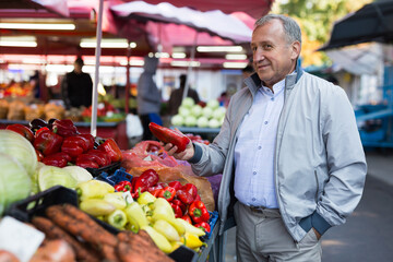 Middle aged man buying peppers