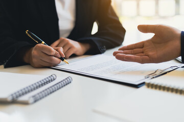 The insurance agent points to the insurance signing document. Businessmen sign business venture agreements. Business partnership signing a contract agreement.