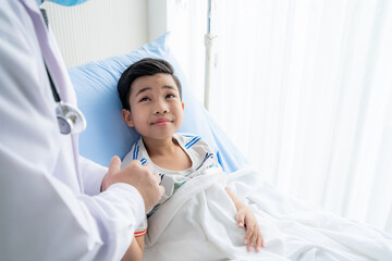 a boy who is reclining in the hospital being encouraged by the doctor