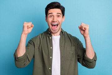 Photo of shocked ecstatic guy win luck lottery raise hands up shout yea isolated on blue color background
