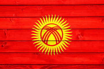 Flag of Kyrgyzstan on wooden surface
