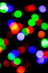 colorful bokeh background in red, green, blue, white, orange. Light from New Year and Christmas electric garlands, blurred background. Holiday concept.