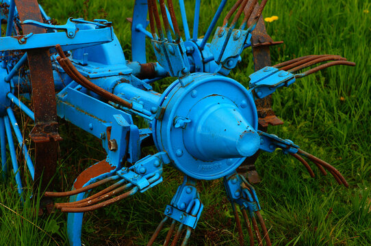 Detail of a historic hay tedder decorating an orchard meadow in Hesse, Germany.