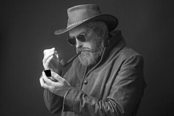 Bearded man in a cowboy hat a weary expression on his face.