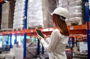 Profile of woman looking into tablet at warehouse