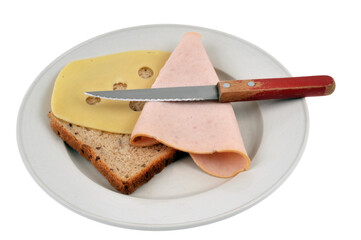 Préparation d'un croque-monsieur avec une tranche de pain de mie, du jambon et de l'emmental dans une assiette avec un couteau sur fond blanc