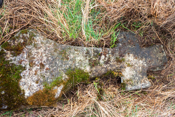 Obraz premium Old stone cross lying in the grass