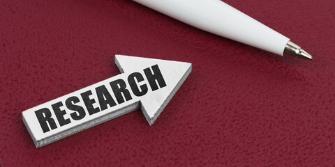 On a red background lies a white pen and a white arrow with the inscription - RESEARCH