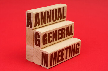 On a red background, wooden blocks with the inscription - Annual general meeting