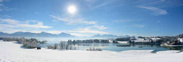 panoramic view to alps mountain range and lake Forggensee in Bavaria at winter