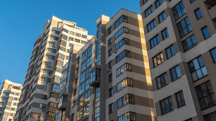 Cramped courtyard near high-rise buildings. A large apartment building in the background of a blue sky.