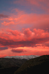 Mountain peaks covered in snow and pink clouds in the sky. Beautiful winter sunset in Croatia.