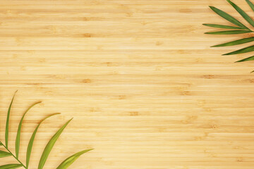 Eco friendly wooden background. Empty wooden kitchen board with palm leaves, flat lay. Mock up for display or montage of product