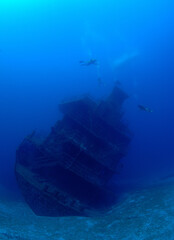  Divers explore an underwater ship wreck.